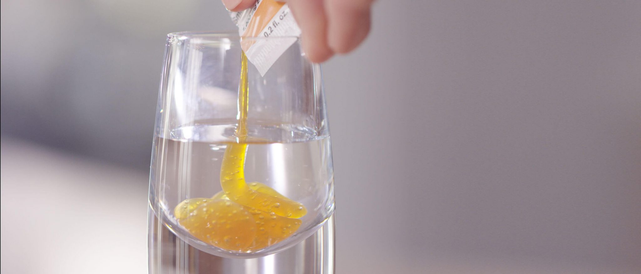 squeezing lypo-spheric vitamin c into a shot glass of water